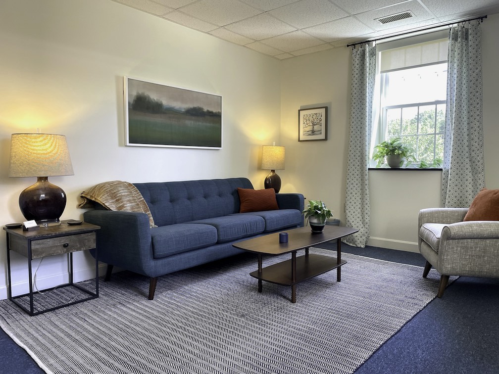 photo of therapy office, sofa, coffee table, and lamps on end tables